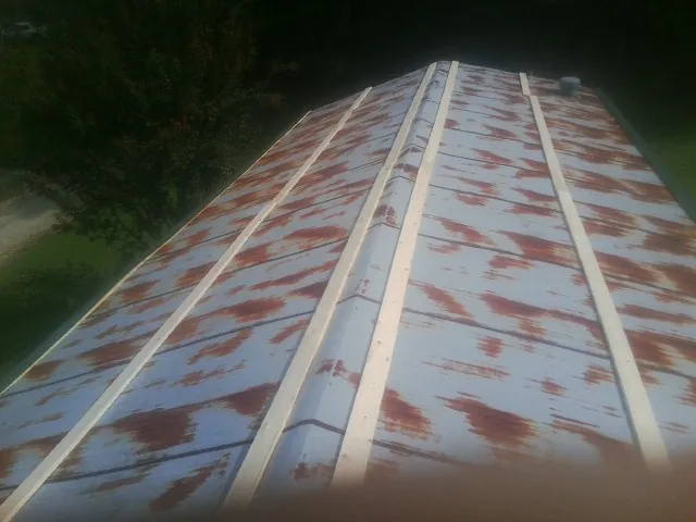 Rusted metal roof panels with new wood purlins before replacement — Storm Damage Roof Repair in Revloc by Roofing Brothers