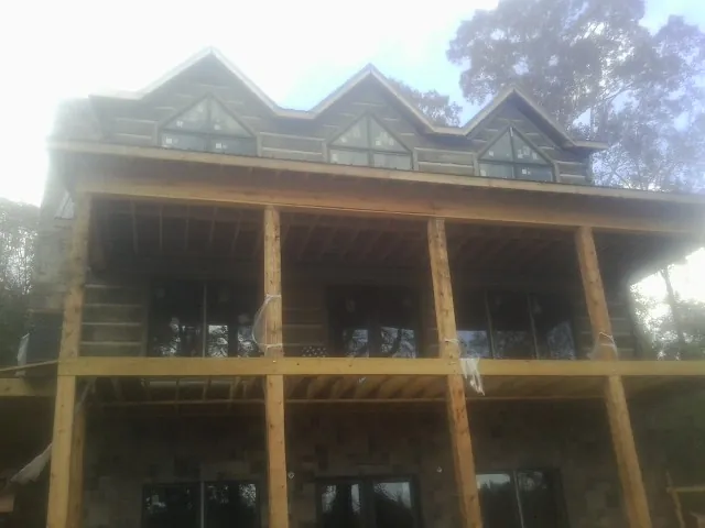 Dormers and porch framing on a large log home under construction — Roof Coating work by our crew in Revloc