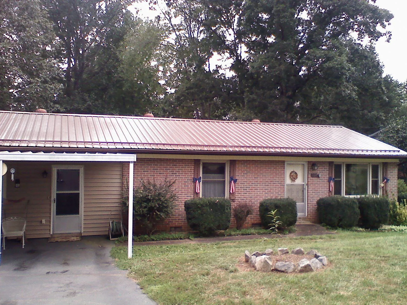 Bronze metal roof and carport on a brick ranch home — Roof Repair work by our crew in Revloc
